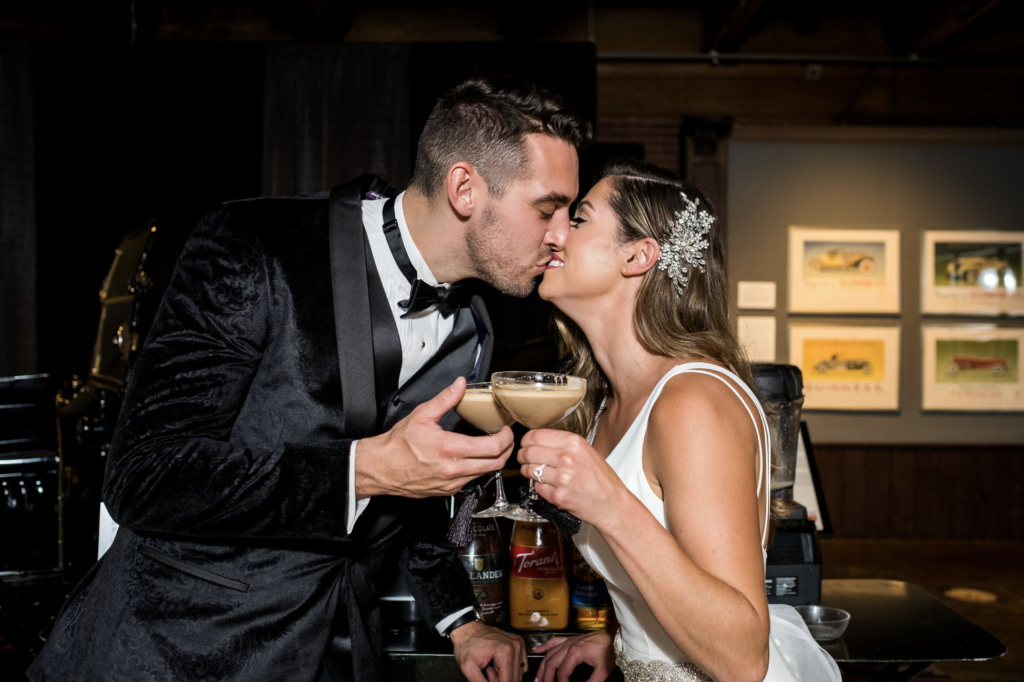 Newly married couple kissing with espresso martinis in glasses. Photo: Christian Napolitano